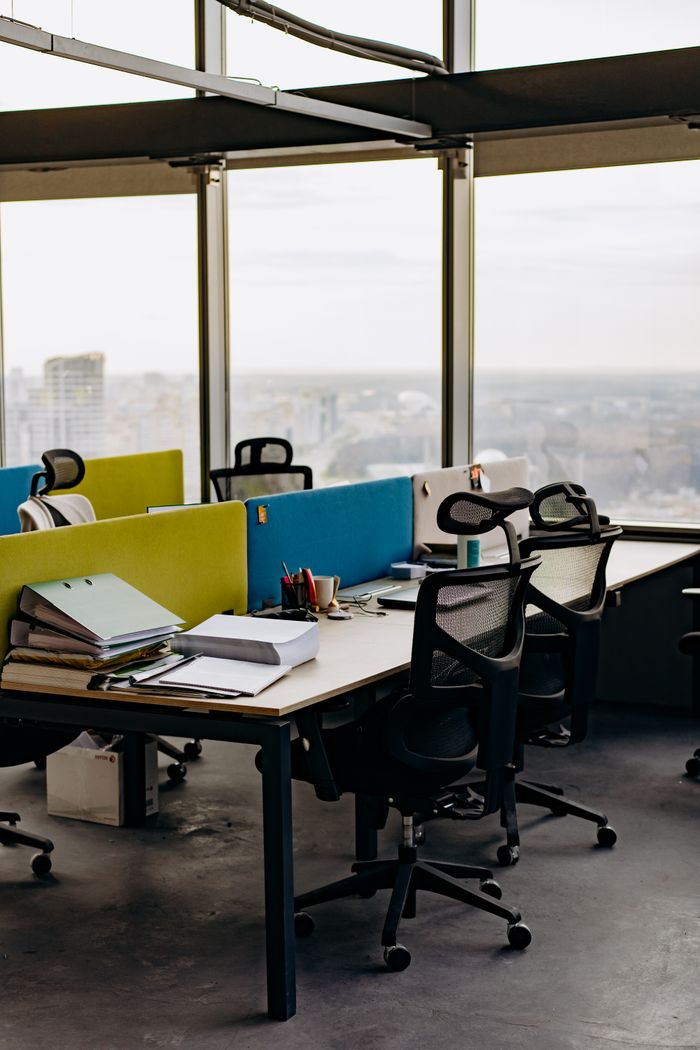 services-bg Open office space with colorful dividers and a city view, typifying modern urban work environments.